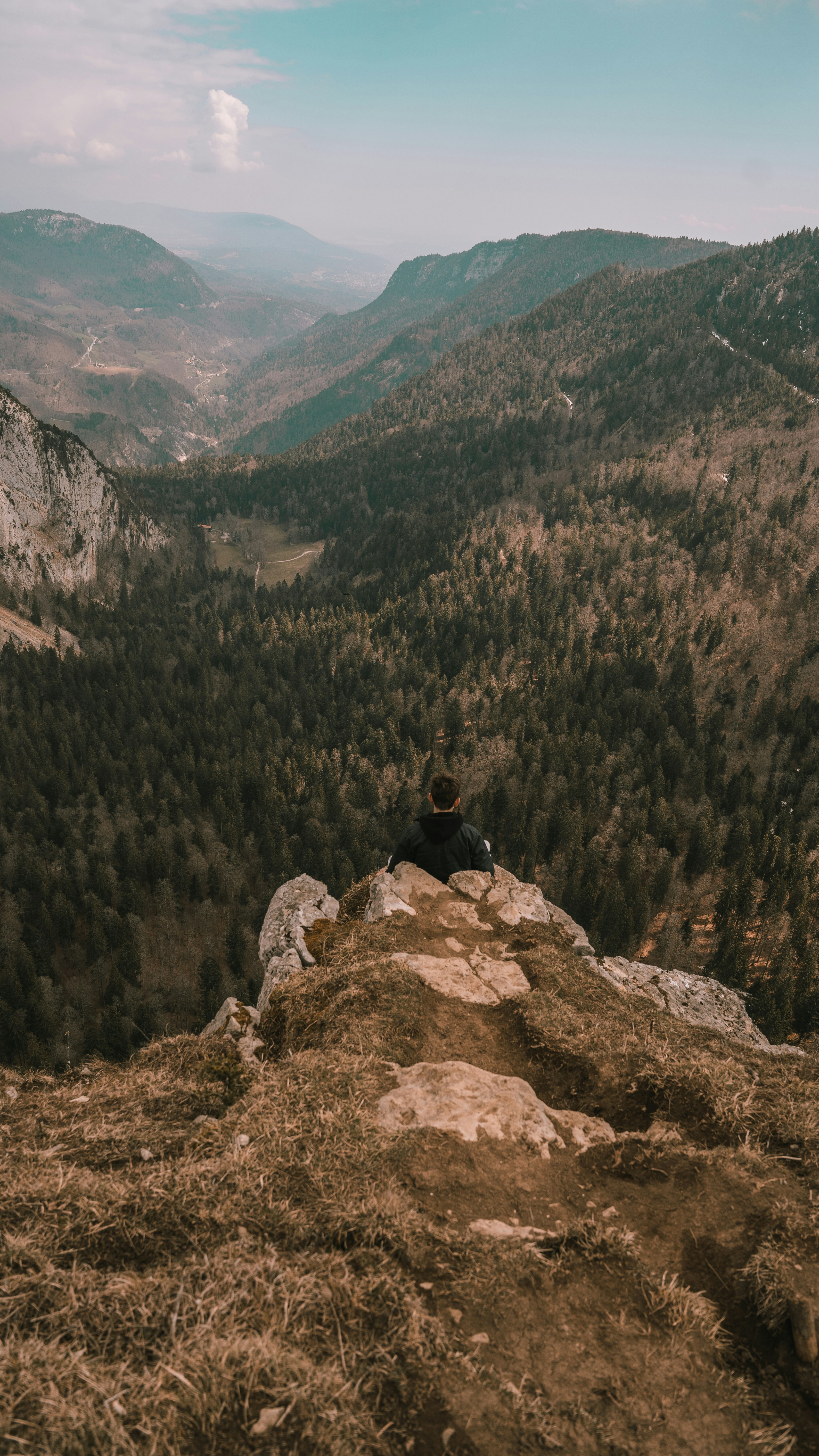 person sitting on rock mountain during daytime